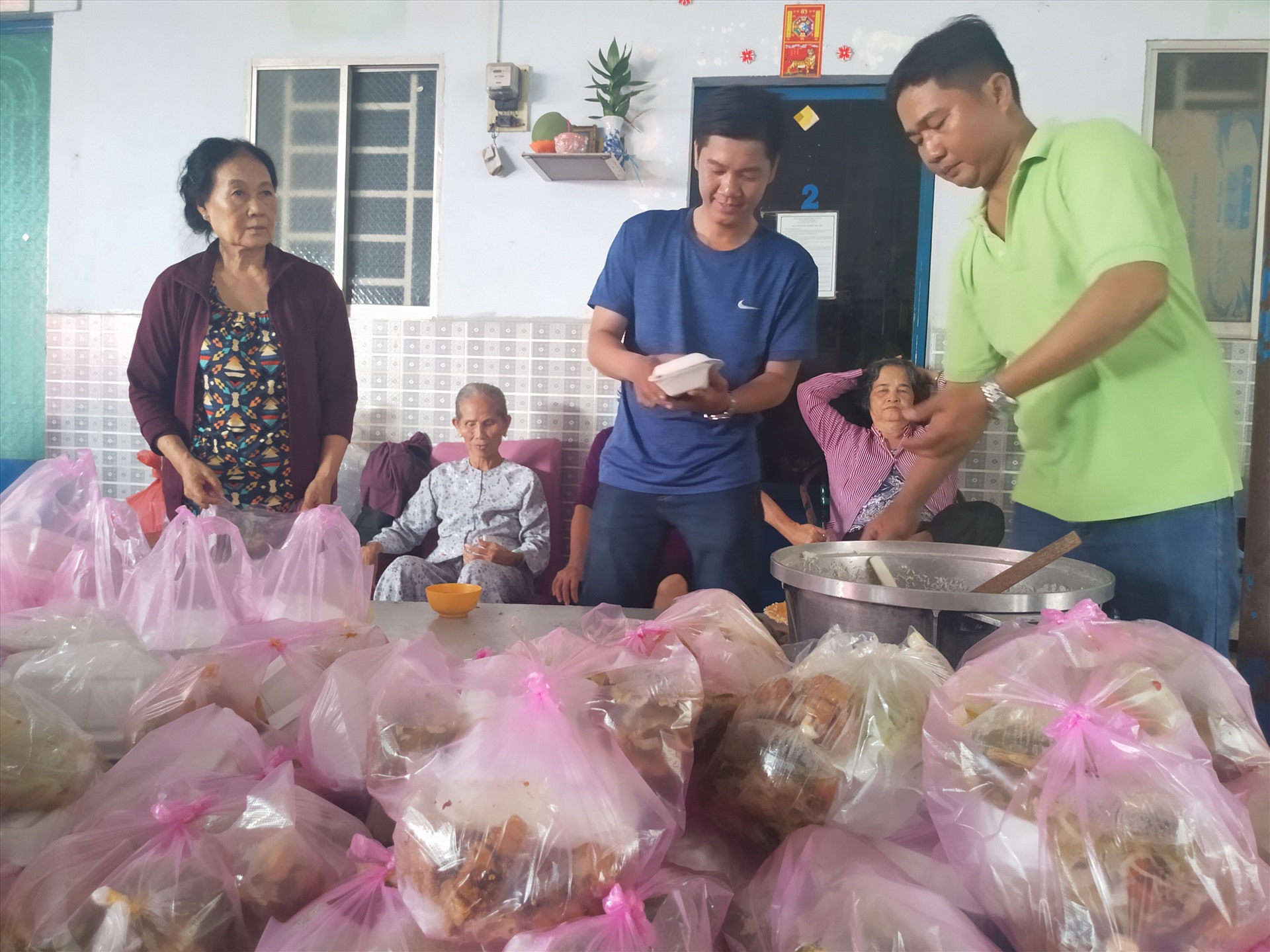 Các tình nguyện viên nam cho cơm vào hộp. Ảnh: K.Q