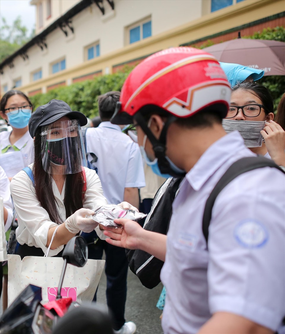 Họ đội mưa phát cho sĩ tử. Ảnh: NSCC