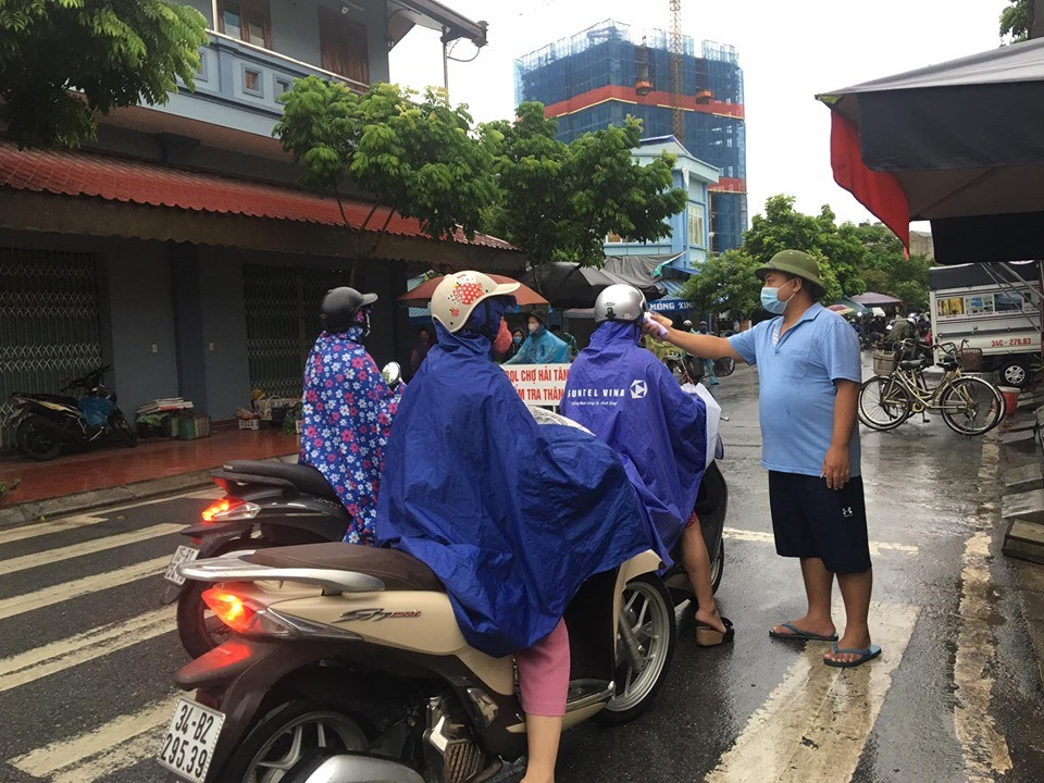 Tại cổng chợ Hải Tân (TP Hải Dương), người dân phải đo thân nhiệt, đeo khẩu trang trước khi vào chợ - ảnh BT