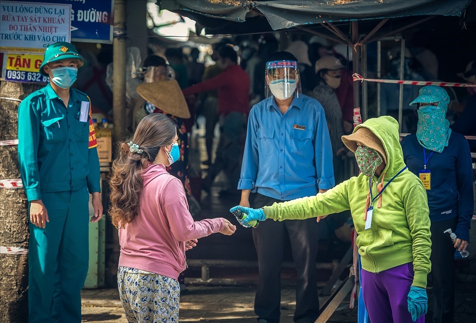 Người đi chợ được cấp thẻ ra vào theo ngày, được đo thân nhiệt, xịt nước sát khuẩn. Ảnh: Kim Liên