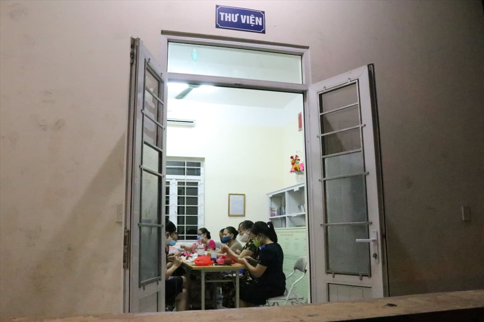 Vào mỗi buổi tối, gần 20 người lại cùng nhau đan móc băng cài gửi tuyến đầu chống dịch. Ảnh: Lan Nhi.