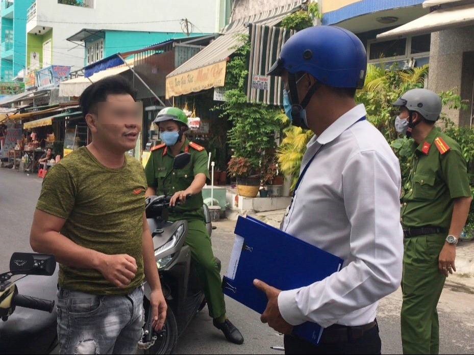 Đoàn kiểm tra của UBND phường phát hiện một trường hợp người dân không mang khẩu trang nơi công cộng. Ảnh: Hữu Huy