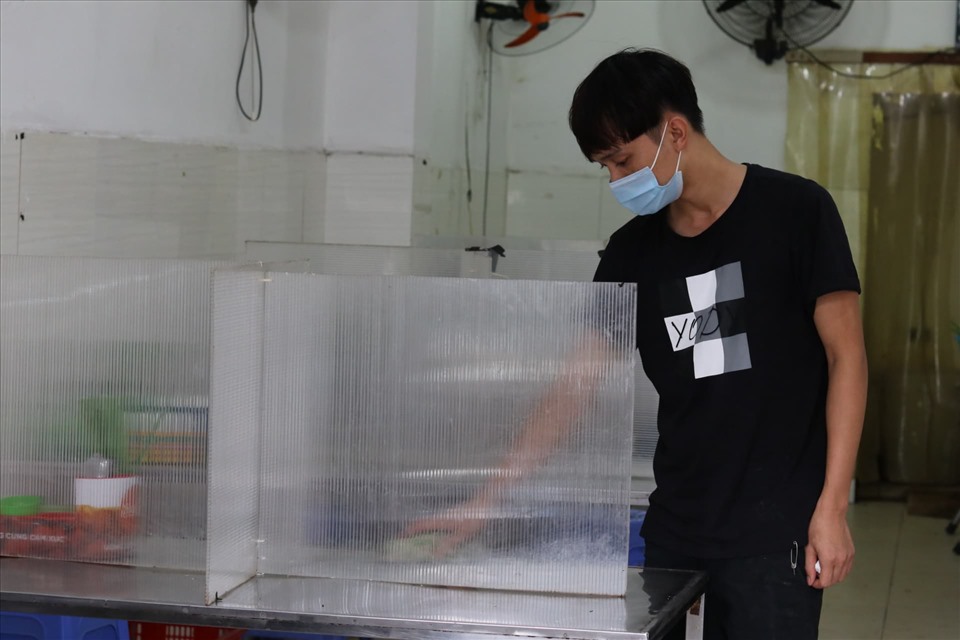 Một số quán cơm đã dựng các bức tường làm bằng mica để tránh lây nhiễm COVID-19. Ảnh: Lan Nhi