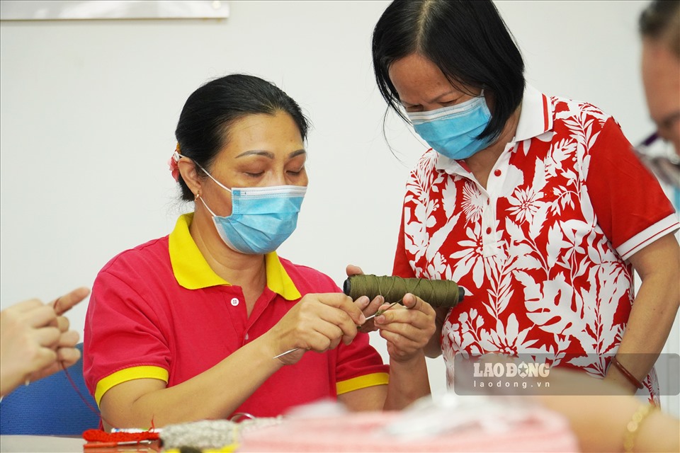 Các cô hỗ trợ, chỉ dạy nhau móc tai giả. Ảnh: Ngọc Lê