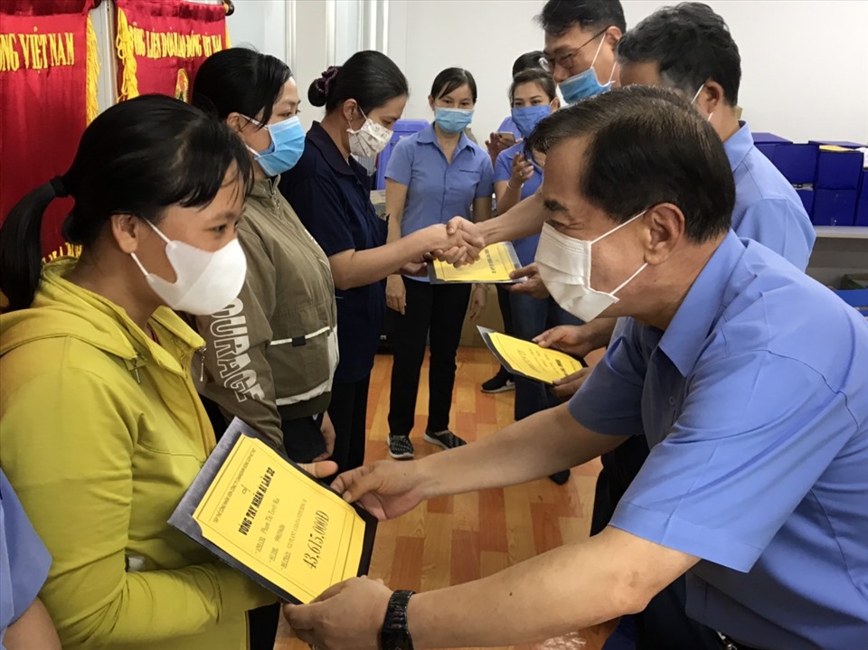 Ông trao hỗ trợ cho công nhân. Ảnh: Hữu Hoà