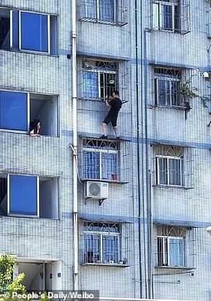 Anh Ge đã mạo hiểm trèo ra ngoài giải cứu cậu bé mà không có bất kỳ thiết bị bảo vệ nào. Ảnh: Nhân Dân nhật báo.