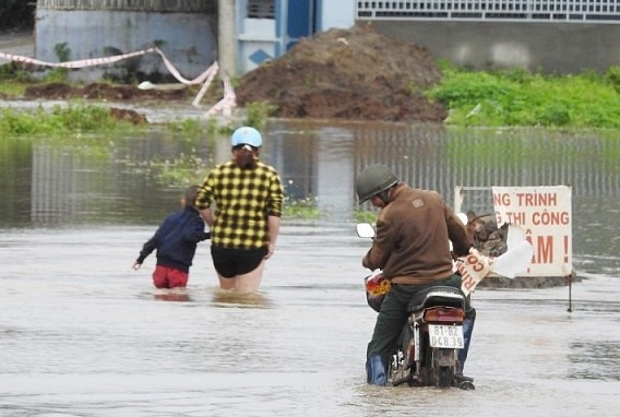 Người dân vừa dắt bộ qua biển nước vừa lo sụp hố ga. Ảnh TA