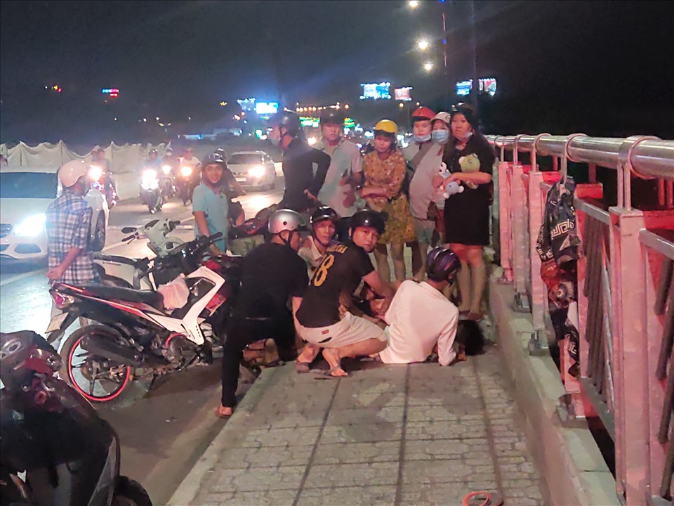 Người dân cùng nhau khống chế được đối tượng nam thanh niêm nhảy cầu tự tử. Ảnh: Thành Nhân
