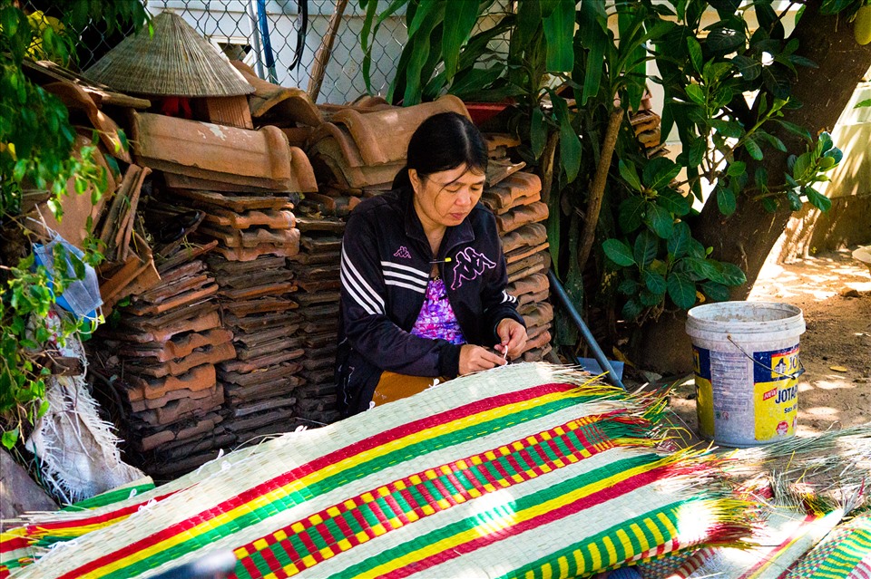 Tỉ mỉ buộc những sợi dây dù trắng quanh mép chiếu.