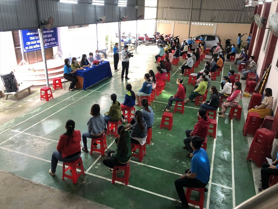 Người lao động nhận trợ cấp thực hiện đúng qui định phòng chống dịch Covid-19. Ảnh: k.Q