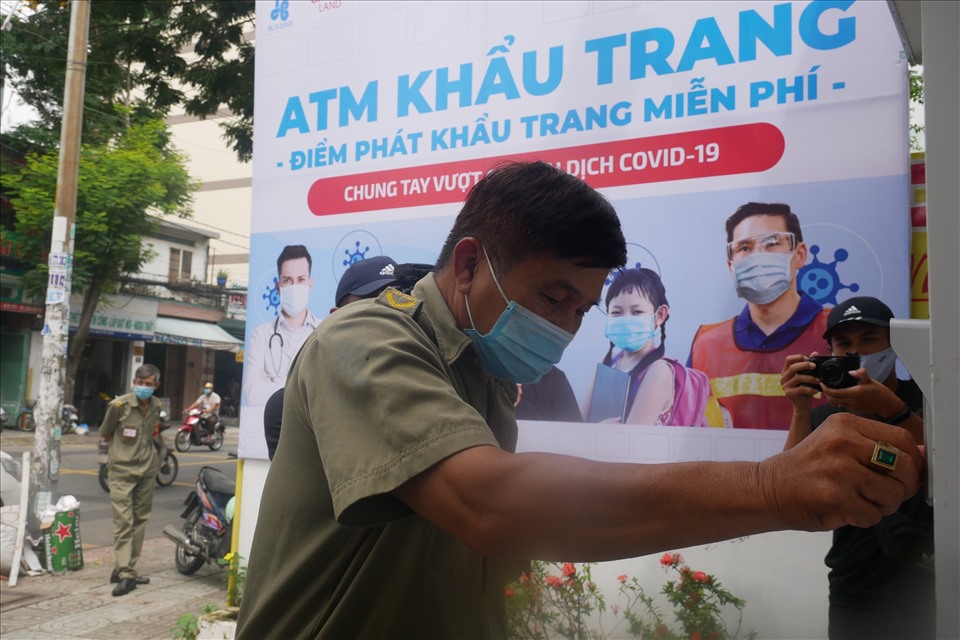 Lực lượng làm nhiệm vụ đảm bảo trật tự trải nghiệm việc nhận khẩu trang tại điểm “ATM“. Ảnh: Anh Tú