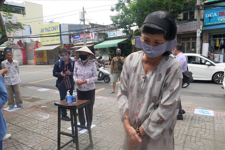 Người dân đến nhận khẩu trang phải giữ khoảng cách an toàn. Ảnh: Anh Tú