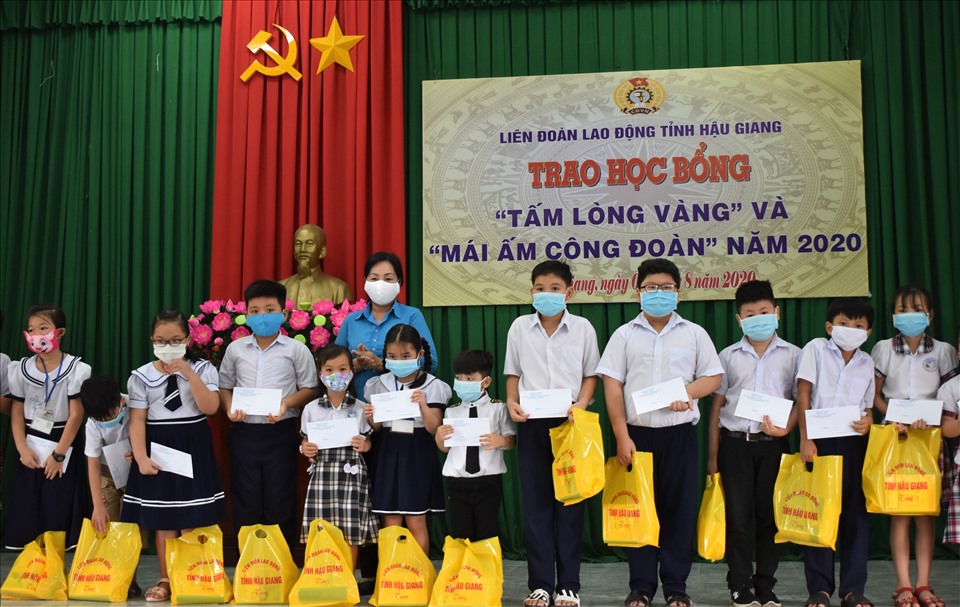 Phó Chủ tịch LĐLĐ tỉnh Hậu Giang Trương Thị Ánh Nguyệt trao học bổng và chúc mừng các em học sinh... Ảnh: Thành Nhân