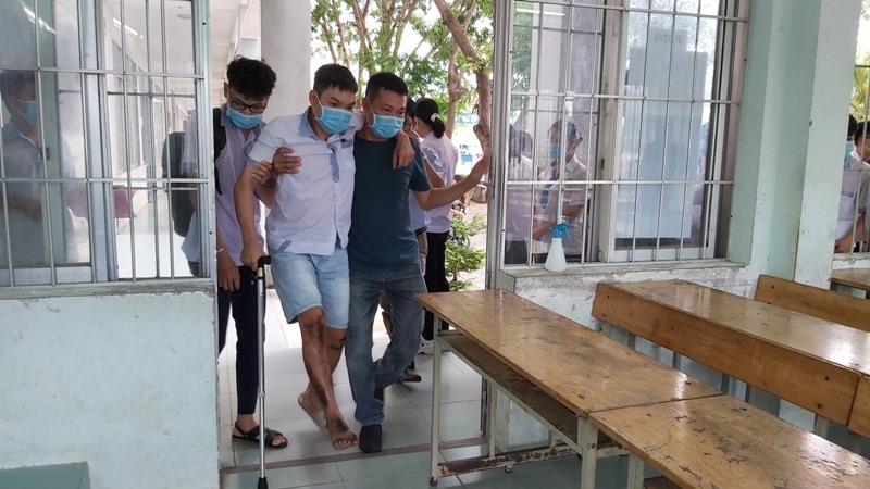 Em Trần Thanh Minh được người nhà dìu vào phòng thi. Ảnh: Nguyên Dũng