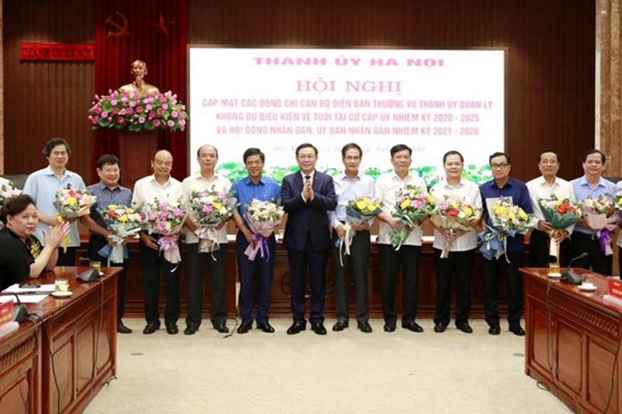 Bí thư Thành ủy Vương Đình Huệ tặng hoa những cán bộ không đủ tuổi tái cử cấp ủy, chính quyền khóa mới. Ảnh: Trọng Toàn/Hanoi.gov