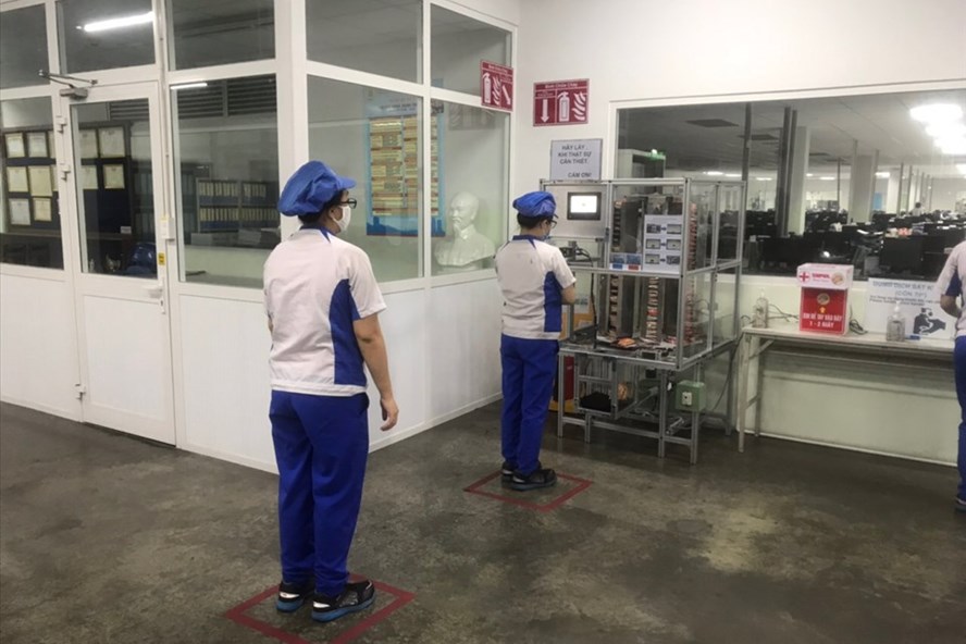 Người lao động Công ty TNHH Mabuchi Motor Đà Nẵng phấn khởi với “cây ATM mỳ tôm” của doanh nghiệp dành cho họ trong lúc khó khăn. Ảnh: Trà Giang