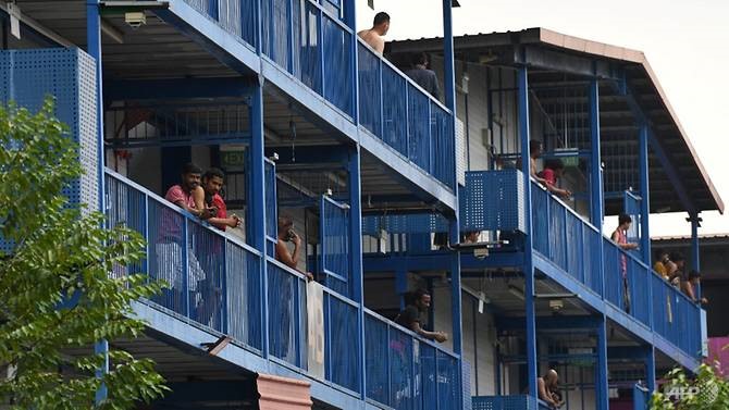 Công nhân nước ngoài đứng dọc hành lang các phòng ở Ký túc xá S11 @ Punggol, Singapore hôm 6.4. Ảnh: AFP.