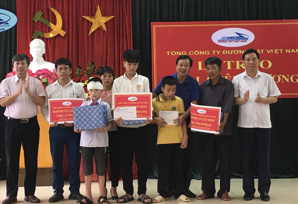 Ông Nguyễn Việt Anh - Chủ tịch Hội đồng quản trị Cty Cổ phần Đường sắt Vĩnh Phú (ngoài cùng bên trái) trao quà hỗ trợ các cháu. Ảnh: Hải Anh