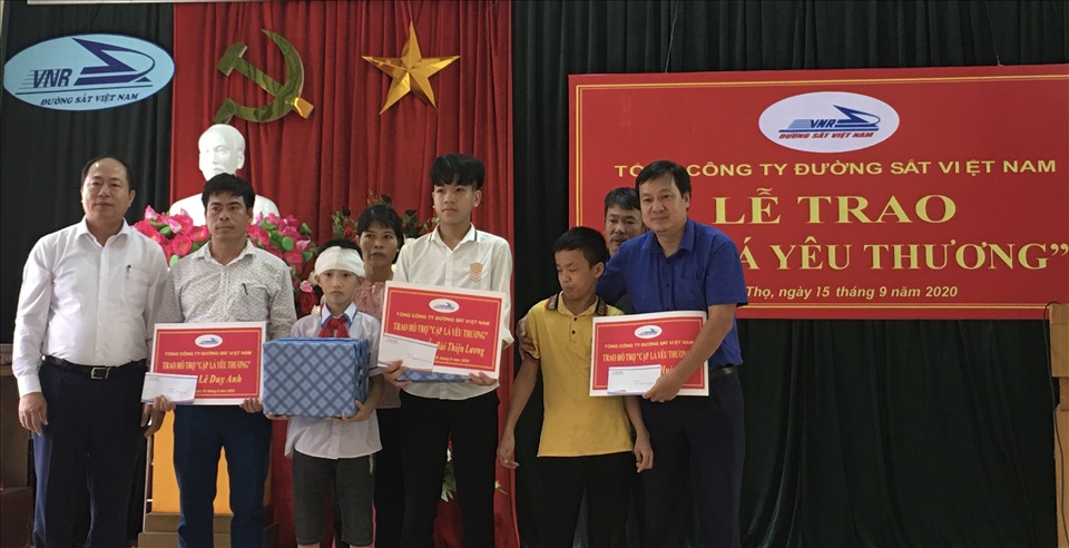 Ông Vũ Anh Minh - Chủ tịch Hội đồng thành viên TCty Đường sắt Việt Nam, (ngoài cùng bên trái) trao biển hỗ trợ “Cặp lá yêu thương”. Ảnh: Hải Anh