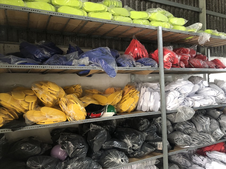 Hàng trăm đôi dép giả nhãn hiệu Adidas đã lên kệ chờ đóng gói ra thị trường. Ảnh: QLTT