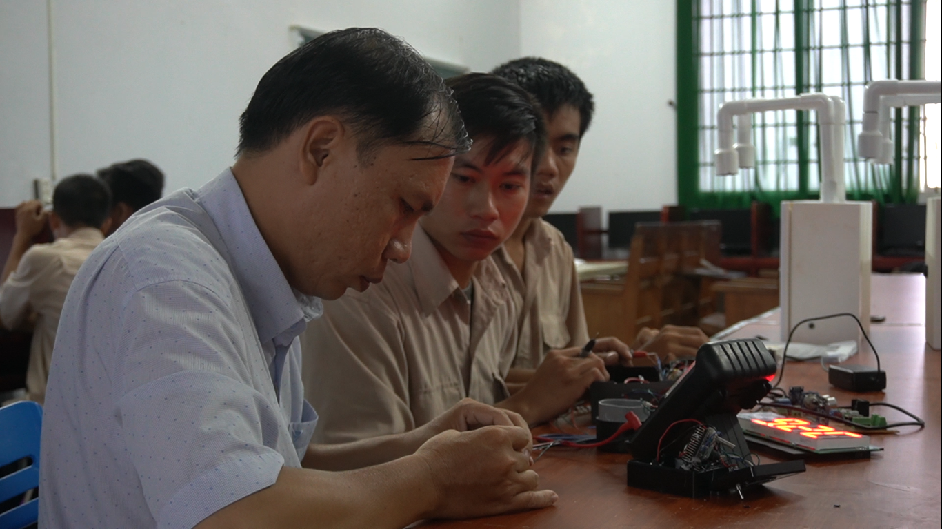Thầy Lê Trung Kiên, Giảng viên Khoa Điện - Điện tử máy tính trường Cao đẳng Nghề Kiên Giang cùng các sinh viên kiểm tra lại hoạt động của máy đo thân nhiệt và sát khuẩn tay tự động. Ảnh: PV