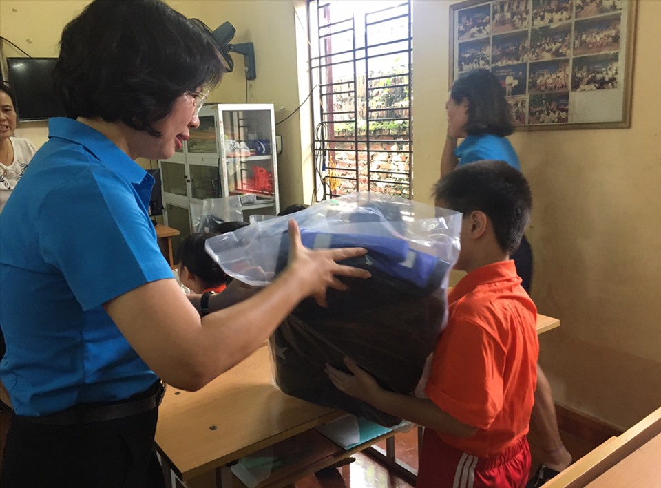 Bà Bùi Huyền Mai - Uỷ viên Ban chấp hành Tổng LĐLĐVN, Chủ tịch Liên đoàn Lao động Hà Nội trao quà cho một học sinh của lớp. Ảnh: Hải Anh