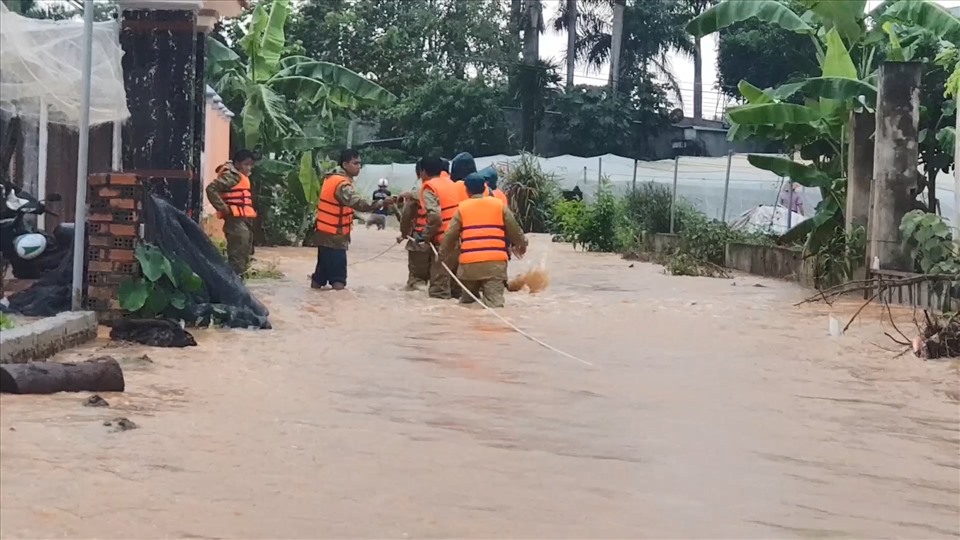 Lực lượng chức năng căng dây tiếp cận nơi nước dâng cao, chảy xiết. Ảnh: Dương Bình