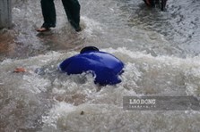 TPHCM: Mưa trút nước, 2 người đi đường bị sụp hố ga được cứu sống