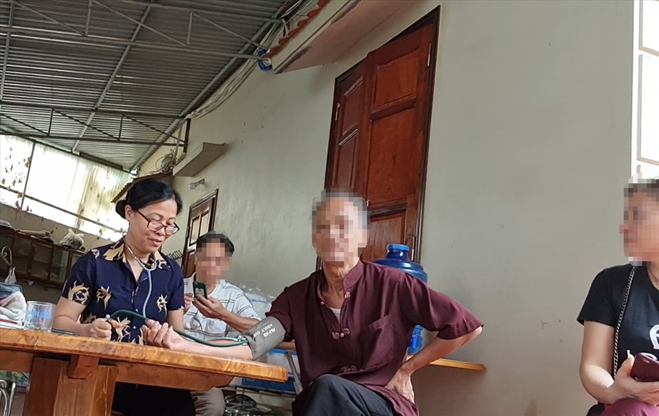 Một cộng sự của bà Tuyền đang tiến hành đo mạch cho các bệnh nhân ở khu vực ngoài sân. Ảnh: LN.