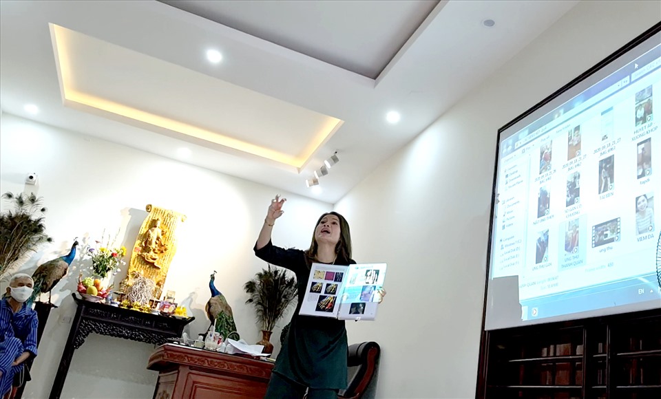 Bà Tuyền sử dụng máy chiếu và Slide dạng bản in để thuyết trình thành thục về khả năng chữa bệnh kì diệu của mình. Ảnh: LN.
