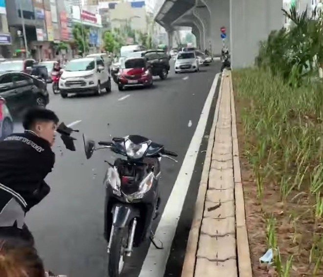 Thanh niên manh động dùng gậy đập phá xe của người đi đường. Ảnh: Cắt từ clip.