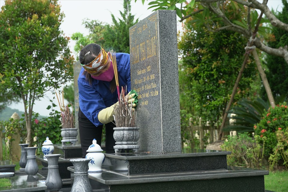 Mỗi ngày, chị Thêm dọn dẹp cho hàng chục ngôi mộ đơn. Ảnh: Huyền Chang