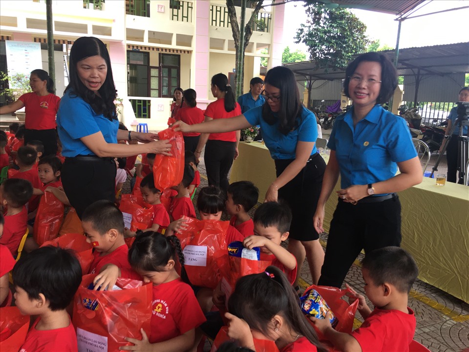 Nhận quà các bác tặng, cháu nào cũng mở túi xem có bánh kẹo không. Ảnh: Hải Anh