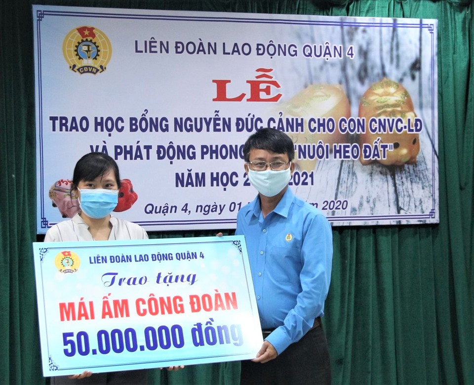 Chị vân nhận bảng tượng trưng kinh phí 50 triệu đồng để xây, sửa “Mái ấm Công đoàn” do LĐLĐ Quận 4 trao tặng. Ảnh Đức Long