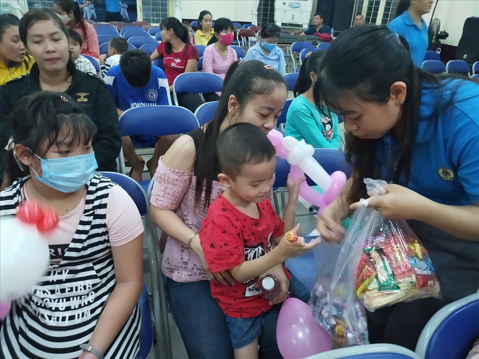 Cán bộ Công đoàn phát bánh, kẹo cho các cháu thiếu nhi. Ảnh: K.Q