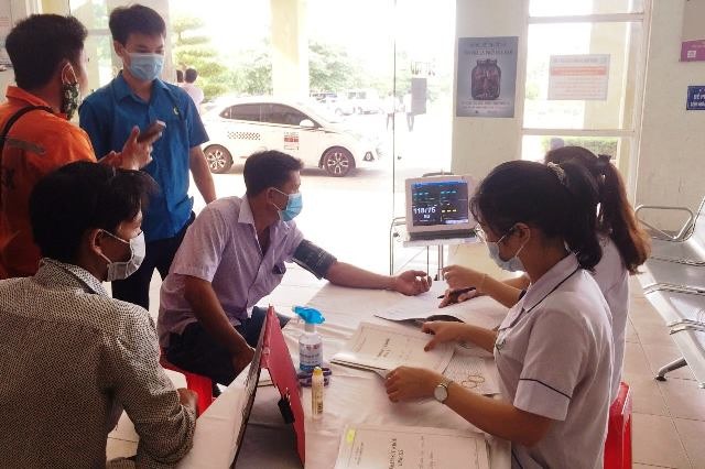 Cán bộ công đoàn động viên, hướng dẫn công nhân khi đi khám sức khỏe. Ảnh: CĐ.
