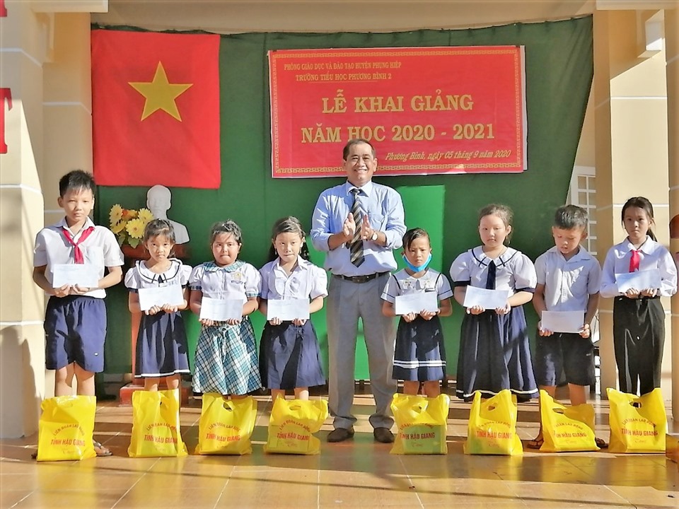 Phó chủ tịch thường trực LĐLĐ tỉnh Hậu Giang Kiều Văn Thọ trao học bổng cho các em học sinh vượt khó học giỏi tại Trường Tiểu học Phương Bình 2. Ảnh: Hoài Phúc