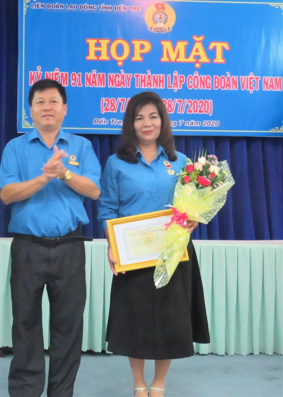 Ông Phan Song Toàn - Chủ tịch LĐLĐ tỉnh Bến Tre - trao khen thưởng cho cô Thủy. Ảnh: K.Q