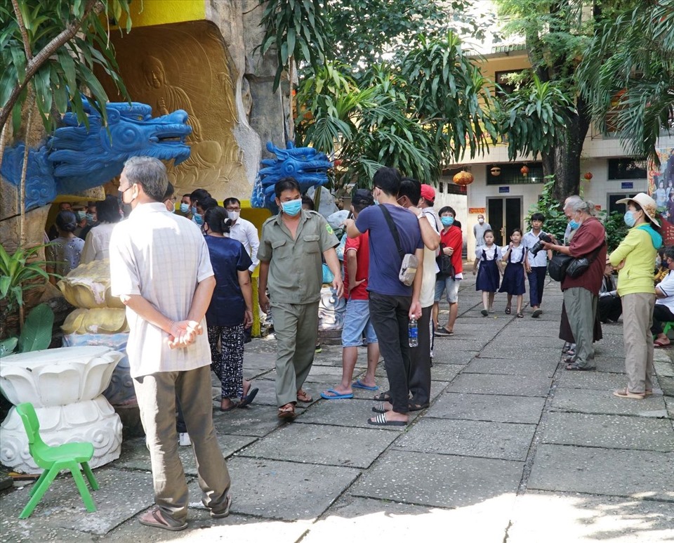 Thân nhân có hũ tro cốt gửi tại chùa Kỳ Quang 2 tập trung trước khu vực lưu giữ tro cốt để theo dõi việc gỡ niêm phong. Ảnh: Anh Tú