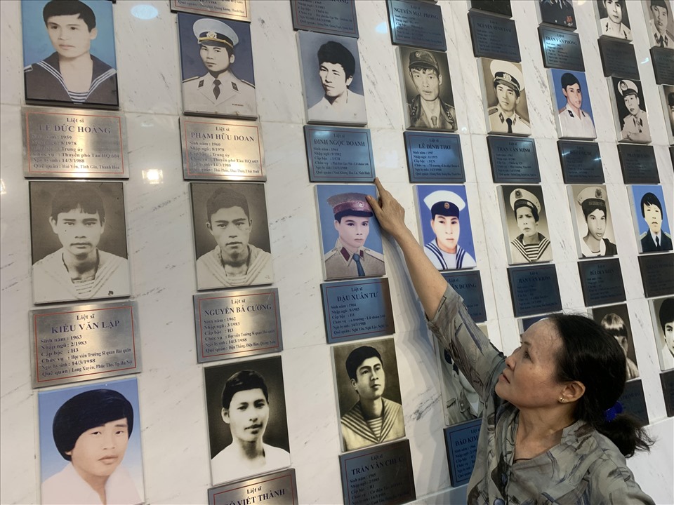 Chị Đỗ Thị Hà, vợ Liệt sĩ Đinh Ngọc Doanh- một trong 64 chiến sĩ đã ngã xuống trong trận chiến Gạc Ma 33 năm trước bên di ảnh của chồng