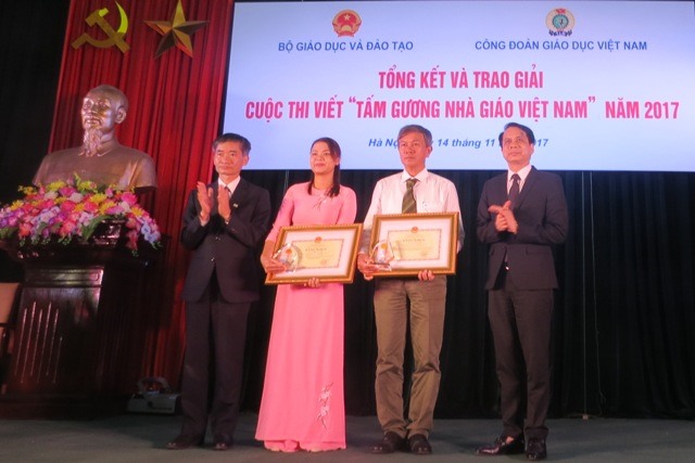 Các ông Trần Văn Thuật - Phó Chủ tịch Tổng LĐLĐVN và Nguyễn Mạnh Hùng - Thứ trưởng Bộ GDĐT trao giải Nhất cuộc thi cho các tác giả. Ảnh: Xuân Trường