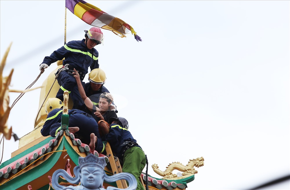 Chớp thời cơ anh ta mất tập trung, 4 cảnh sát liền ập vào khống chế, dùng day thừng buộc vào cơ thể để đảm bảo an toàn cho anh ta. Ảnh: Trường Sơn