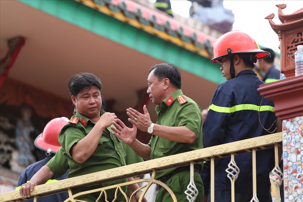 Các lực lượng công an, cảnh sát vừa thực hiện các phương án đảm bảo an toàn, tiếp cận người thanh niên, đồng thời bàn các phương án khả thi nhất để đưa người này xuống đất. Ảnh: Trường Sơn