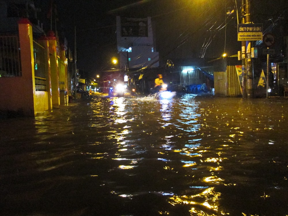 Tuyến Quốc lộ 13 cũ (Thủ Đức) bị ngập nặng khiến nhiều xe gắn máy lưu thông bị chết máy phải dắt bộ. Ảnh: Đ.L