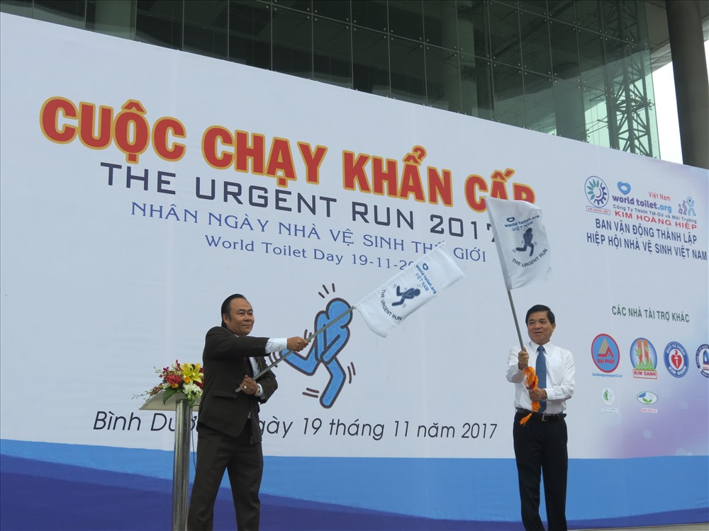 Trưởng đại diện tổ chức World Toilet tại Việt Nam Lê Văn Hiệp (trái ảnh) và Phó Chủ tịch UBND tỉnh Bình Dương Trần Thanh Liêm phất cờ xuất phát cuộc chạy - Ảnh: L.T