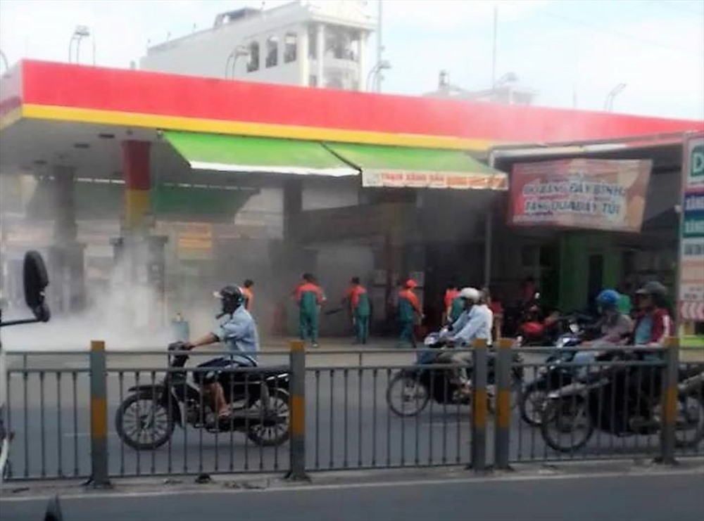 Nhân viên cây xăng dùng các phương tiện sẵn có dập lửa. Ảnh: T.S