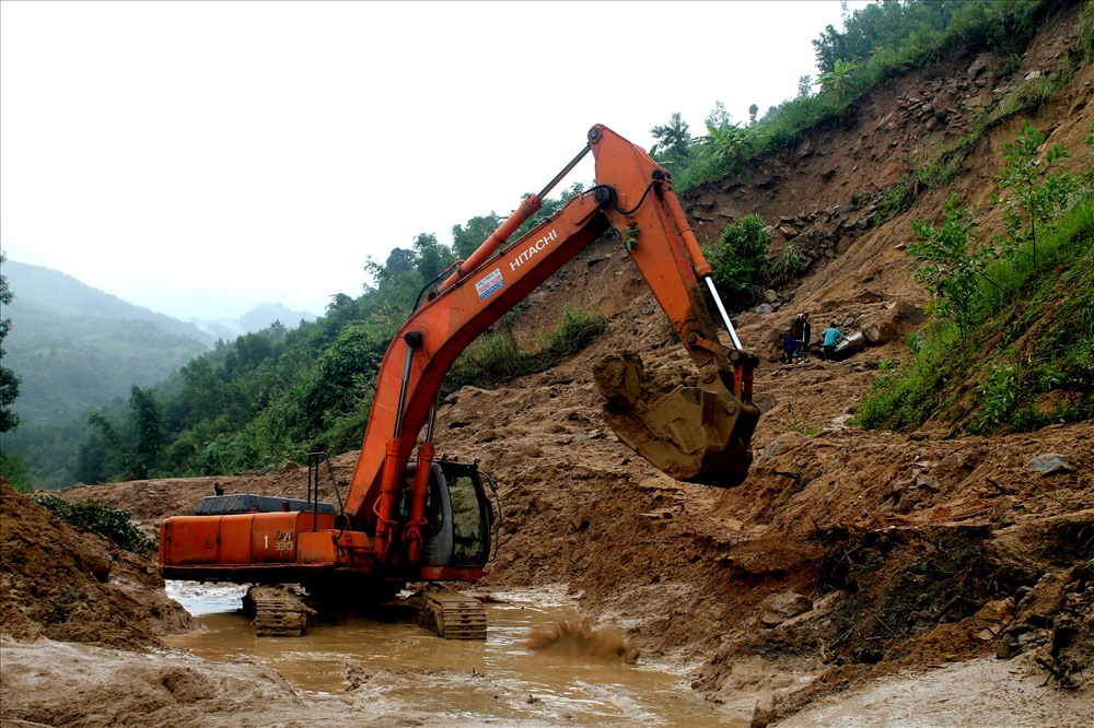 Lực lượng chức năng đang khắc phục điểm sạt lở gần cầu sông Tang (xã Trà Xinh). Ảnh: T.H