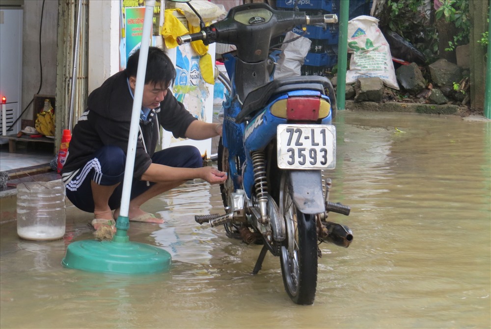 Rửa xe bằng nước lũ. Ảnh: Hưng Thơ.