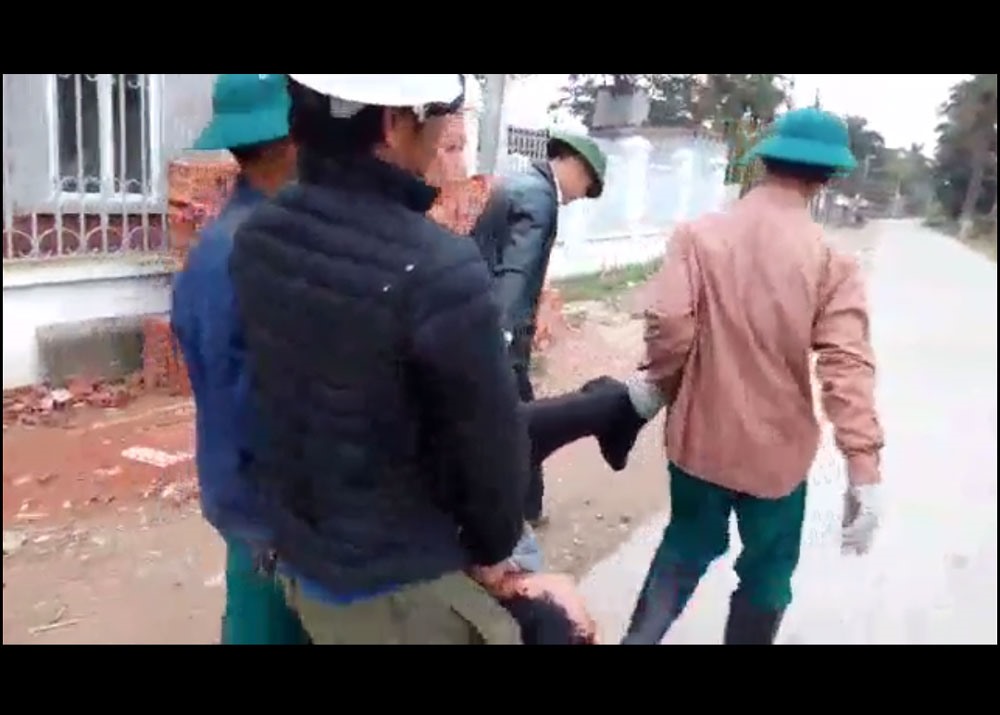 Công an còng tay, khênh người về xã làm việc - ảnh cắt từ clip .
