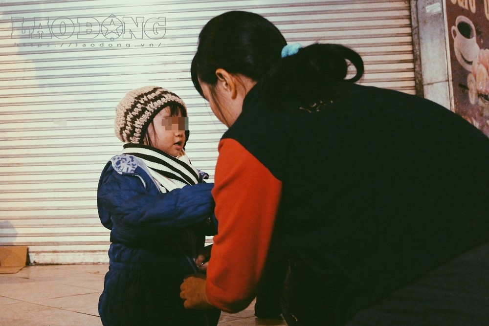 Người mẹ kéo khóa áo khoác, giữ ấm cho con.